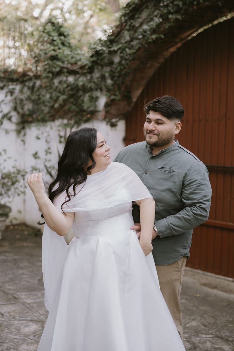 Karla y Christian frente a una puerta roja con hiedra