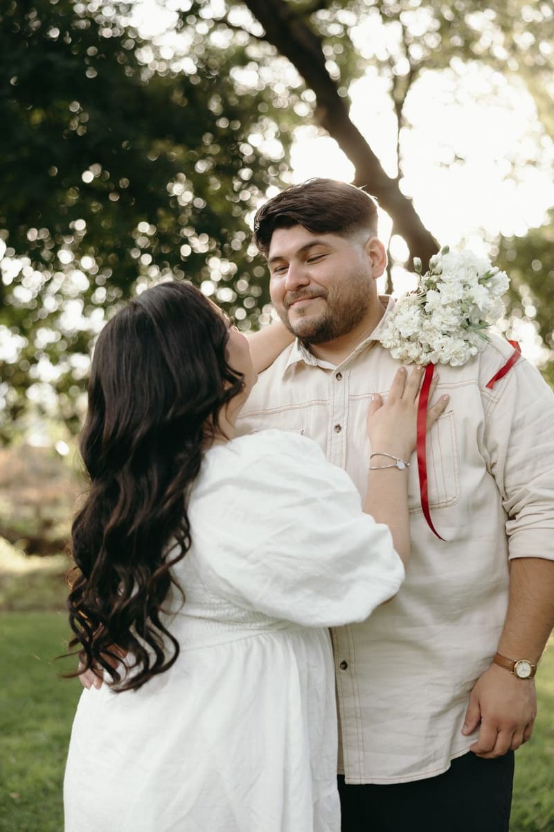 Karla abraza a Christian, que lleva un ramo con listón rojo